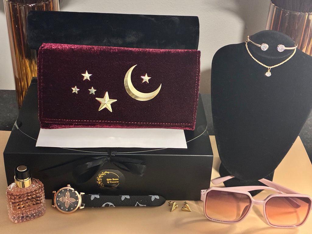 Jewelry set with a wallet, sunglasses, perfume, and watch on a table.