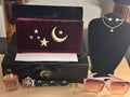 Jewelry set with a wallet, sunglasses, perfume, and watch on a table.